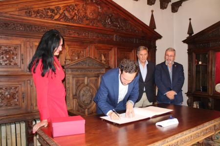 Imagen: Isaac Claver firma en el Libro de Honor del Ayuntamiento de Huesca