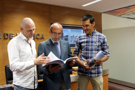 Imagen: Francisco Mateo ojea la guía con dos de sus autores